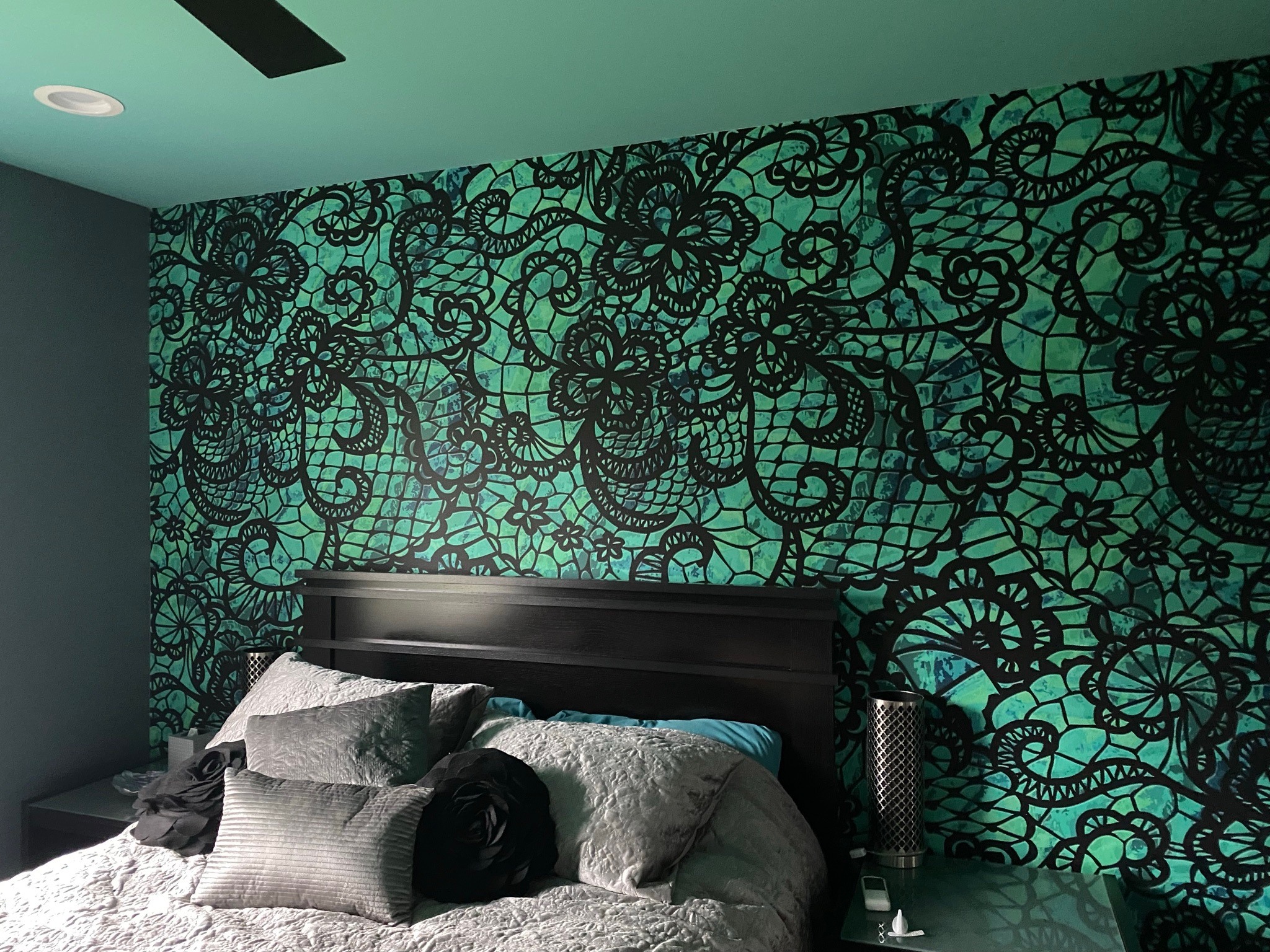 Black lace-pattern wall wrap on a teal bedroom feature wall