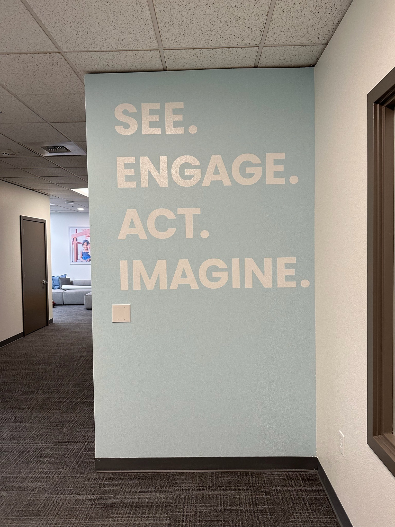 White See Engage Act Imagine lettering on a blue interior wall