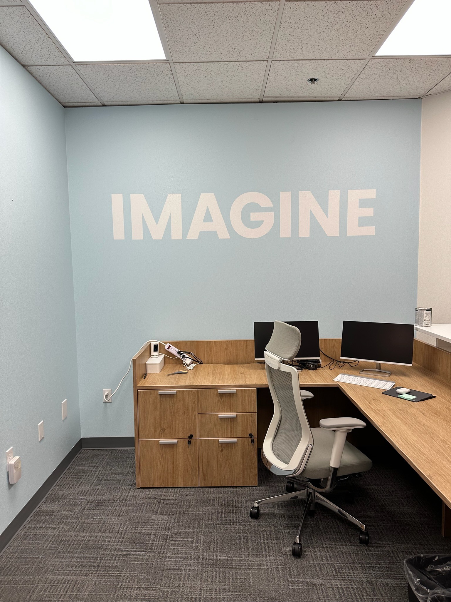 White Imagine lettering above an office desk