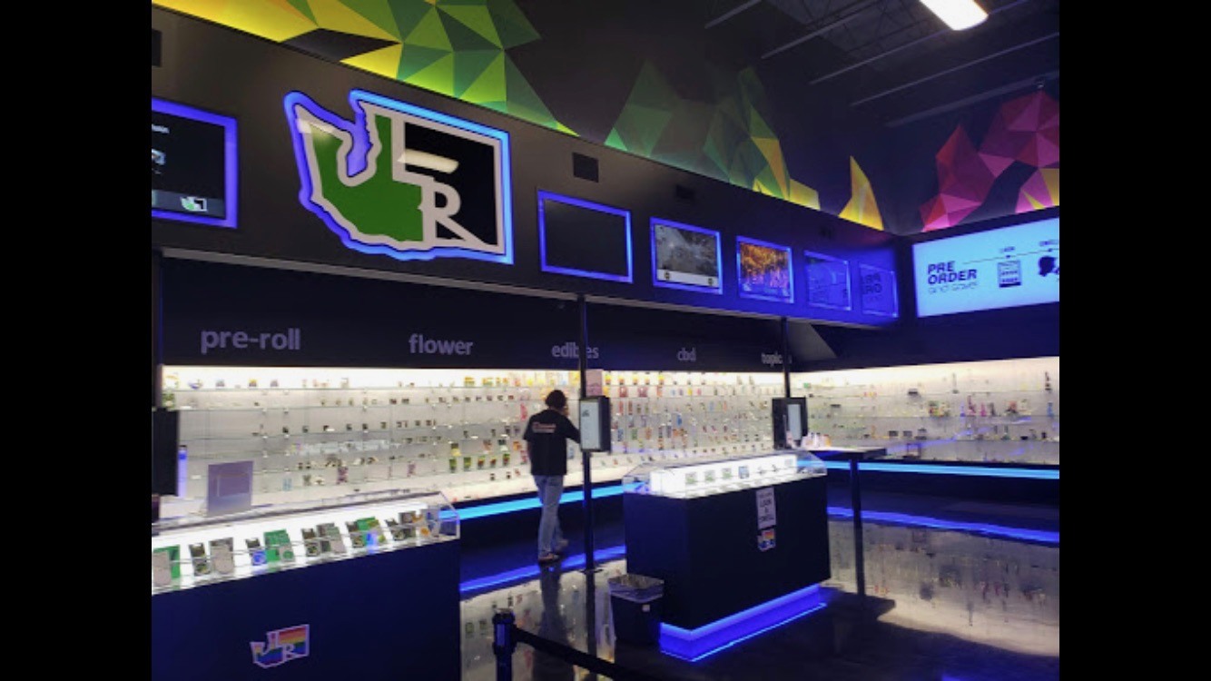 Local Roots retail interior with colorful geometric graphics above display cases