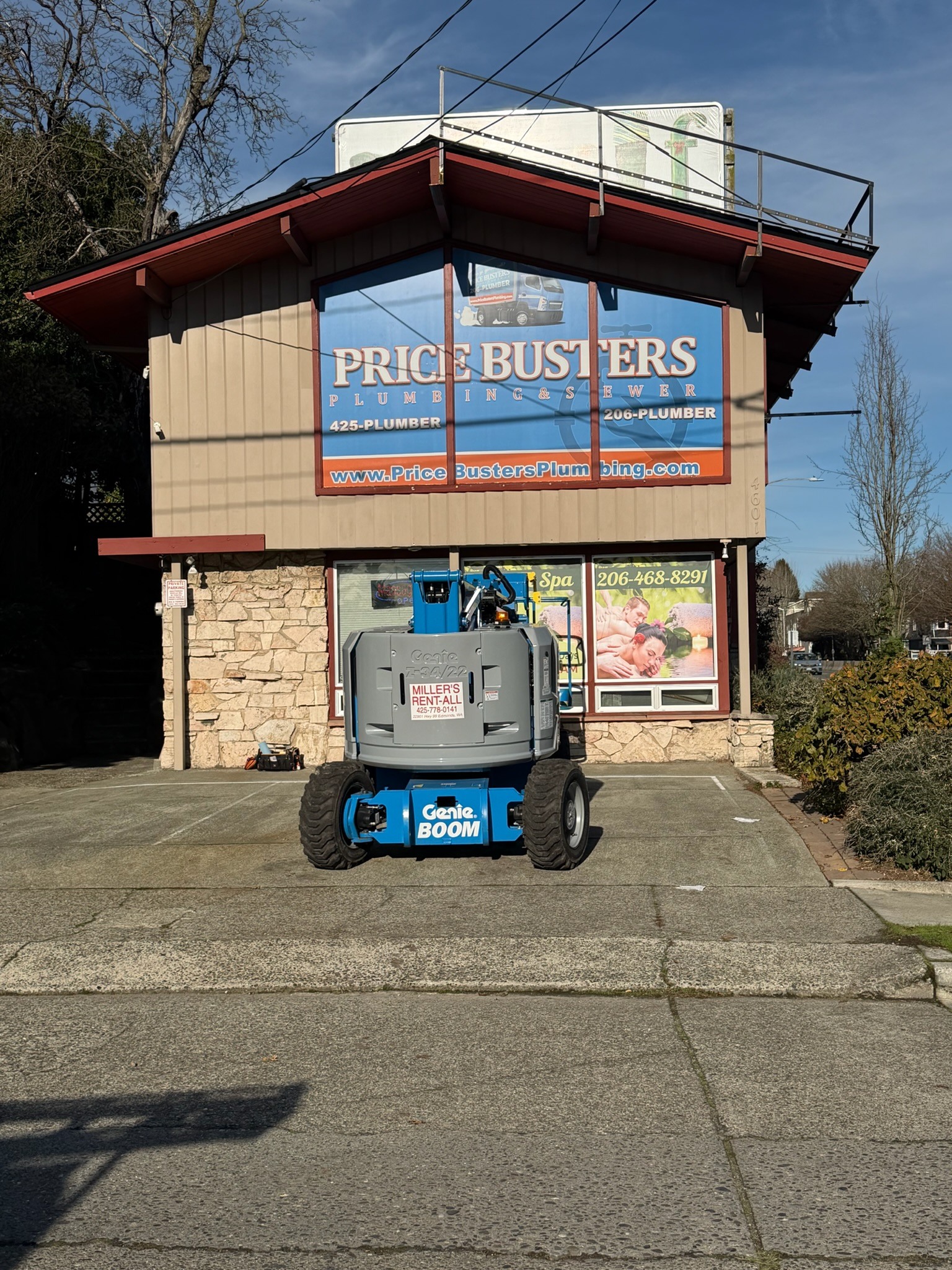Price Busters Plumbing graphics across upper storefront windows