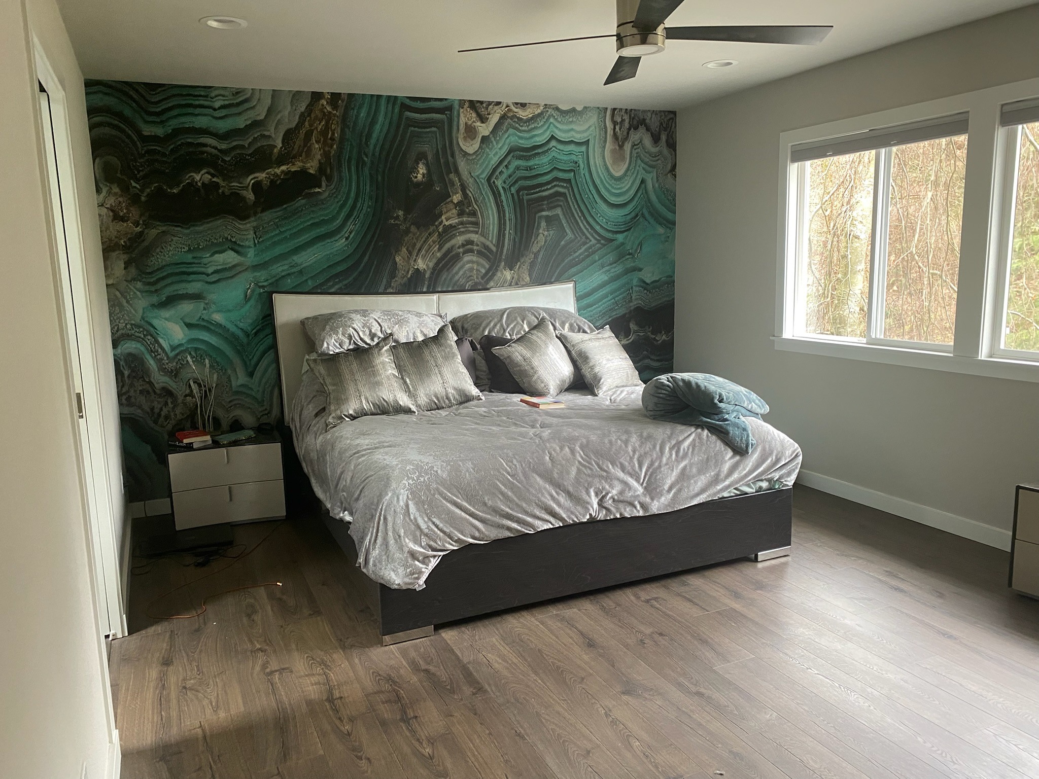 Green and charcoal rock-effect wall wrap behind a bed
