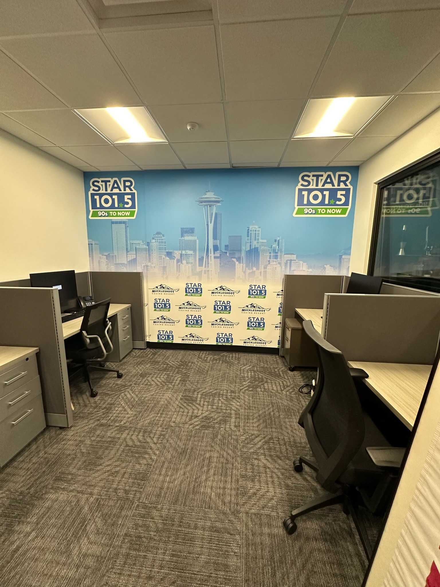 STAR 101.5 skyline and logo wall wrap behind office desks
