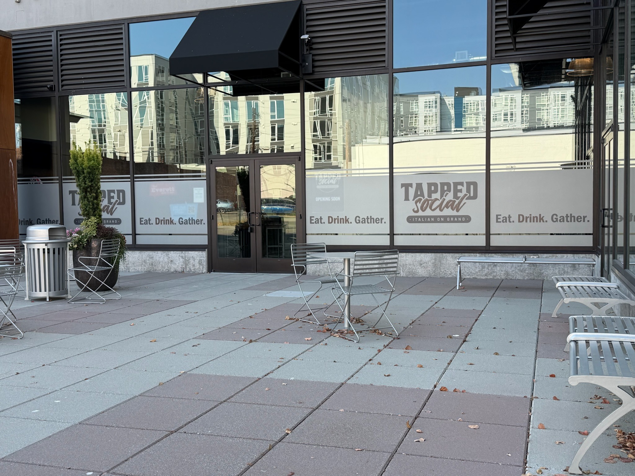 Tapped Social House storefront with frosted window graphics and branded lettering.