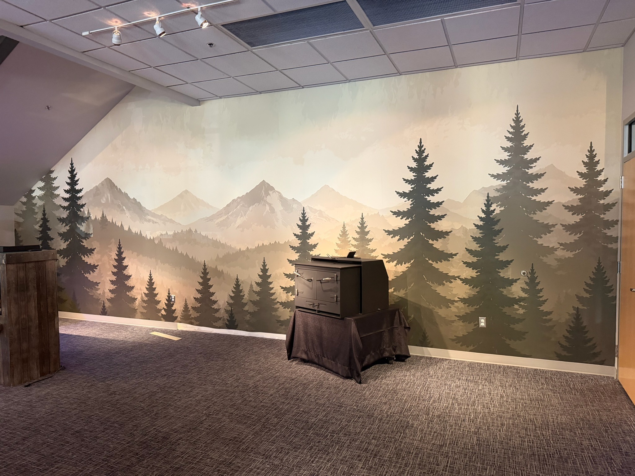 Mountain and evergreen wall mural inside the Travis Industries showroom.